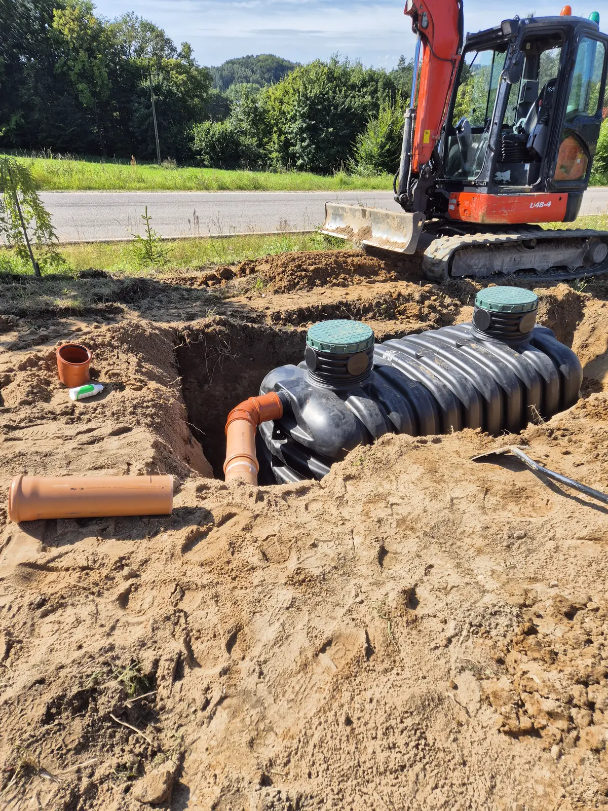 Montaż przydomowej oczyszczalni ścieków z plastikowym zbiornikiem w wykopie ziemnym