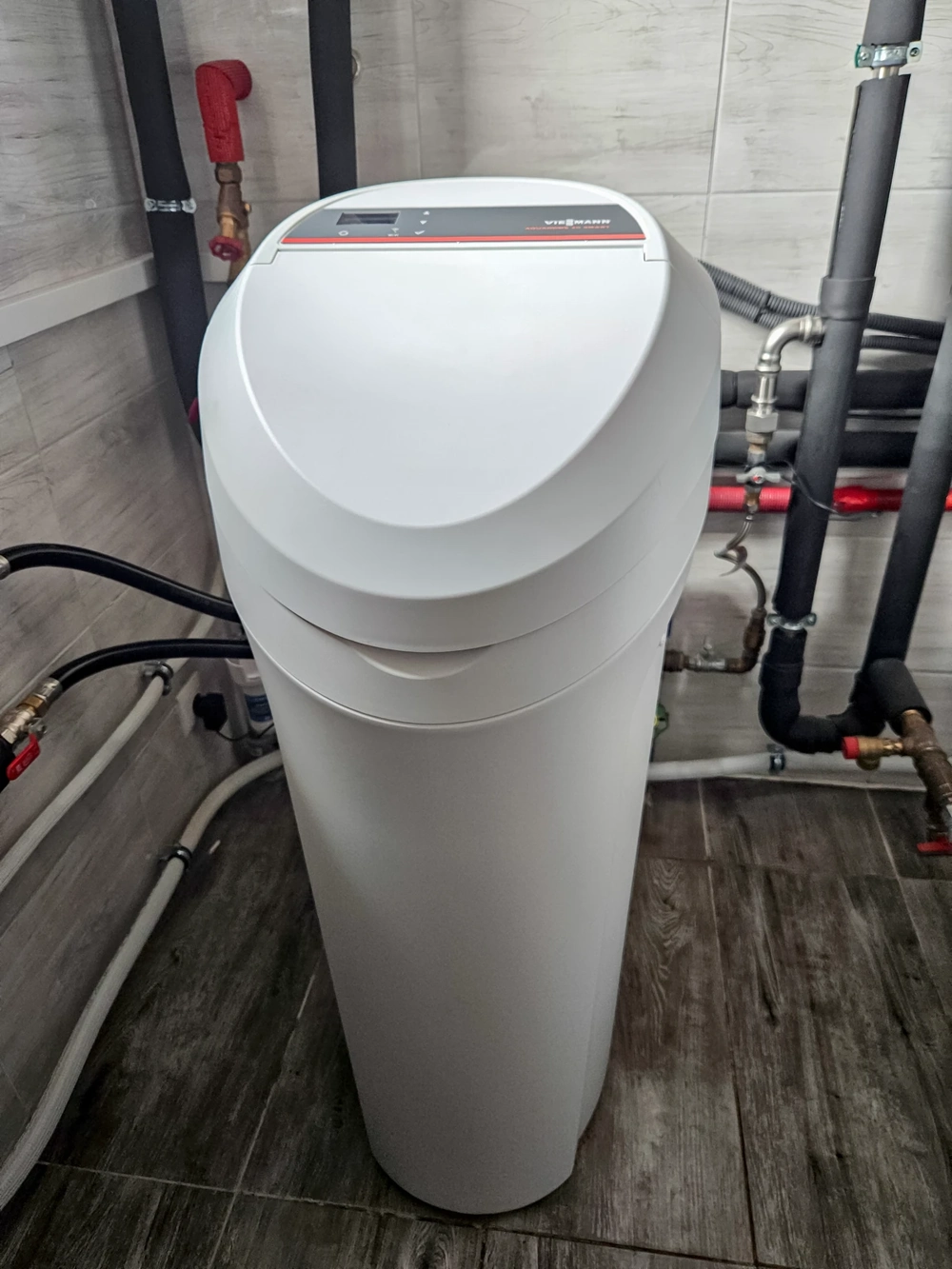 Uzdatniacz wody w pomieszczeniu technicznym z instalacją rur wodno-kanalizacyjnych